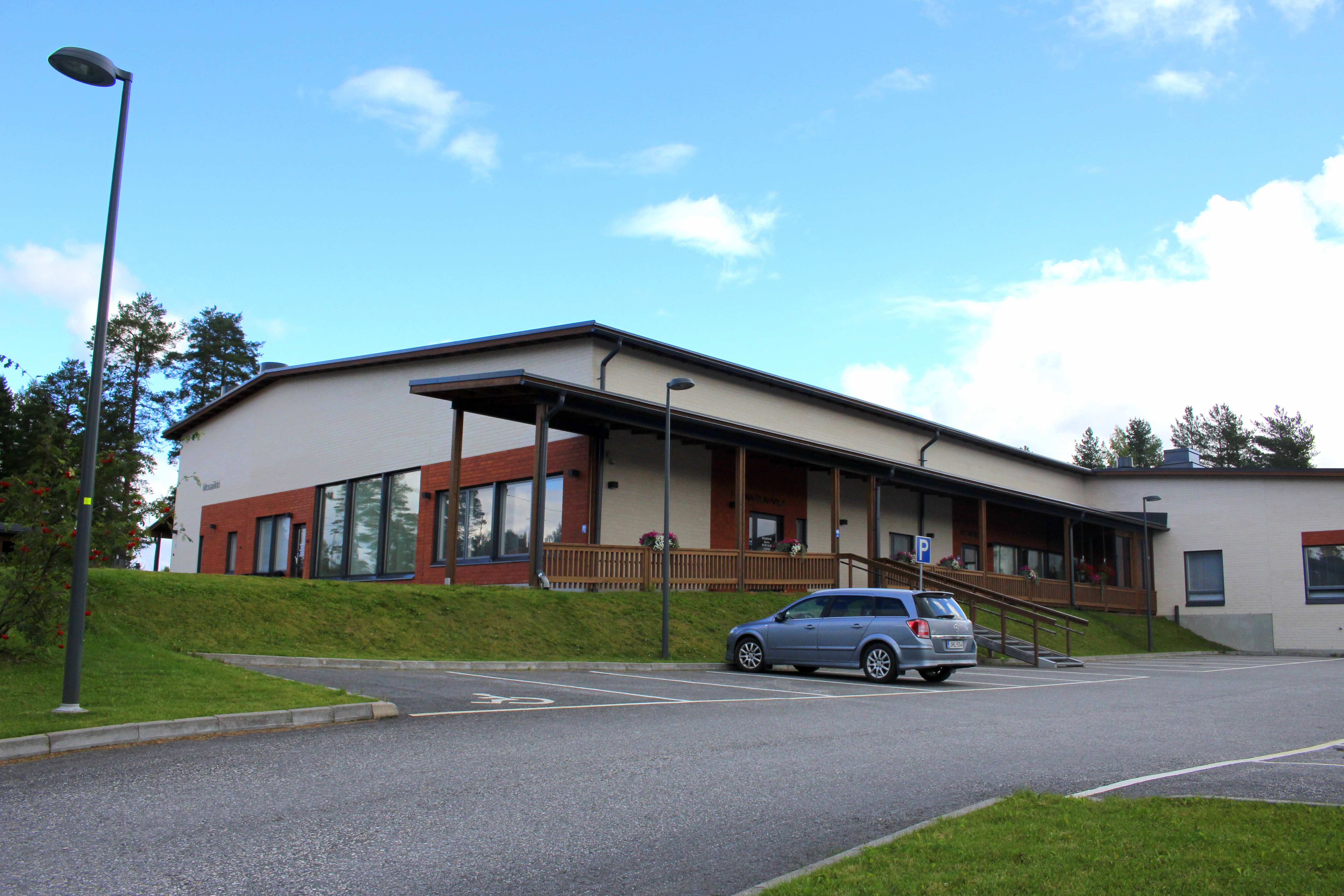 Vaalea/punainen yksikerroksinen rakennus Mosaiikki Koulutiellä Sonkajärvellä